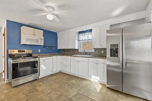 a kitchen with stainless steel appliances granite countertop a stove a sink and a refrigerator