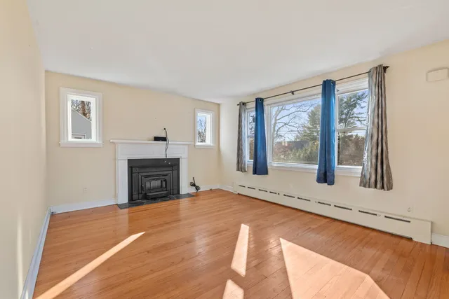 a view of an empty room with a fireplace and a window