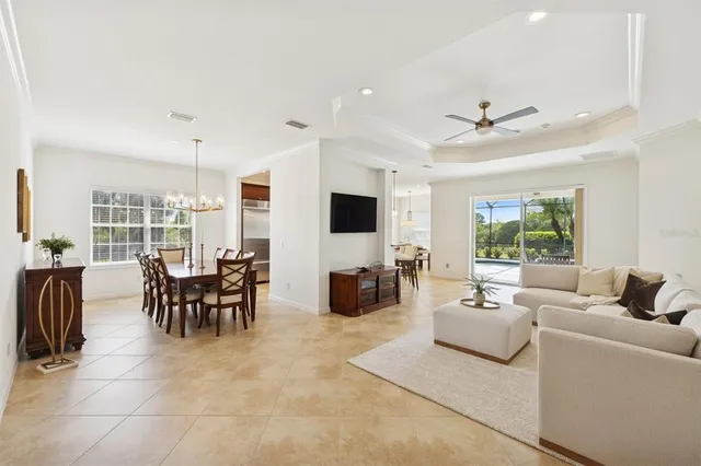a living room with furniture kitchen view and a flat screen tv