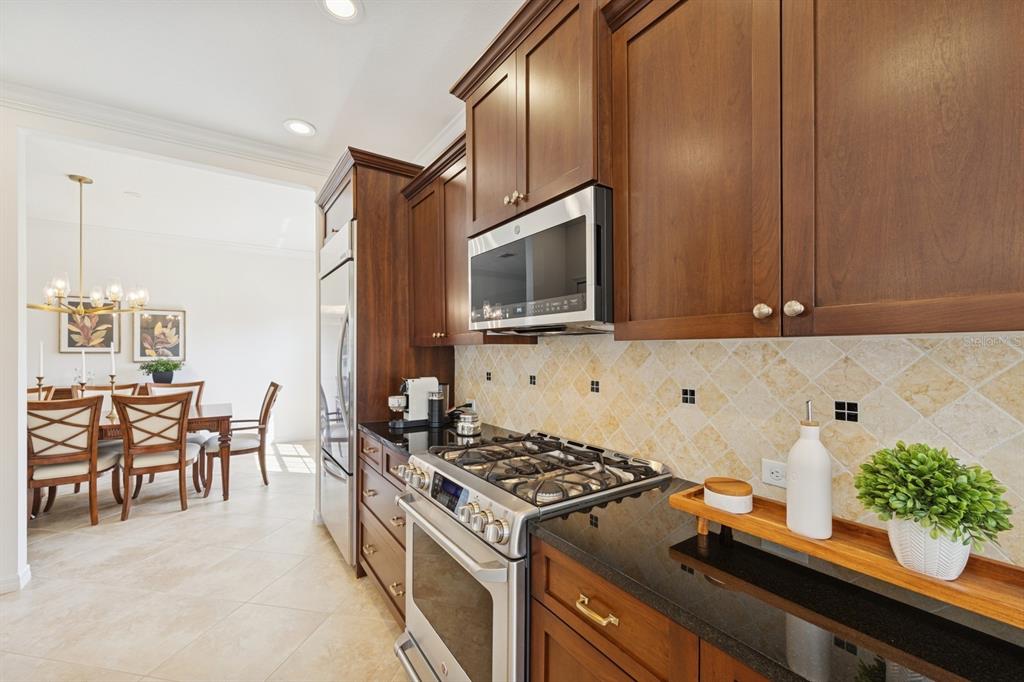 14614 Newtonmore Lane Lakewood Ranch, FL 34202 - Photo 16 of 72 a kitchen with stainless steel appliances a stove a sink and a microwave