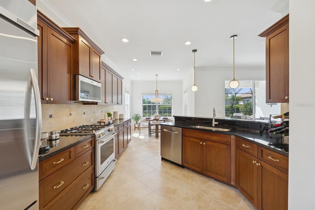14614 Newtonmore Lane Lakewood Ranch, FL 34202 - Photo 21 of 72 a large kitchen with stainless steel appliances a stove a sink dishwasher a oven and a refrigerator