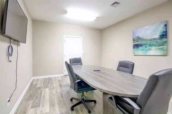 a view of a workspace with furniture and wooden floor