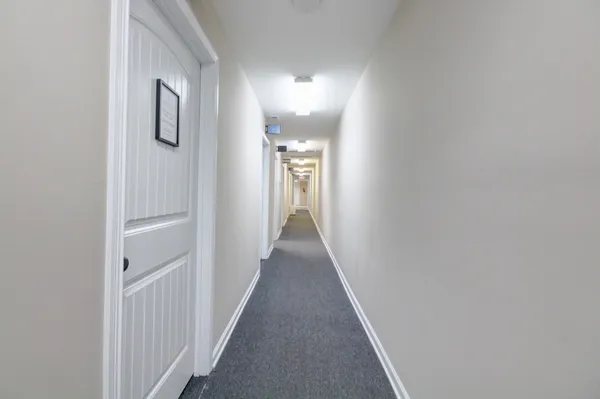 a view of a hallway with wooden floor