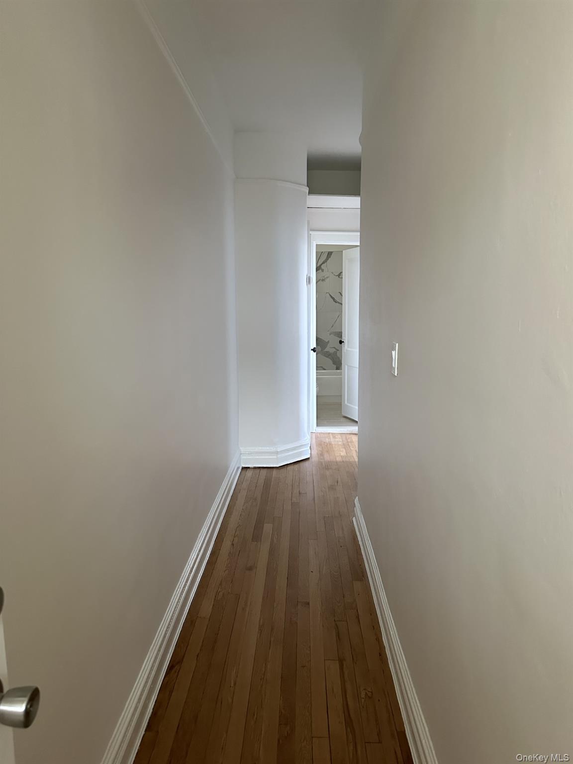 117 Plandome Road, Unit 2R Manhasset, NY 11030 - Photo 4 of 13 Hallway with hardwood flooring and baseboards