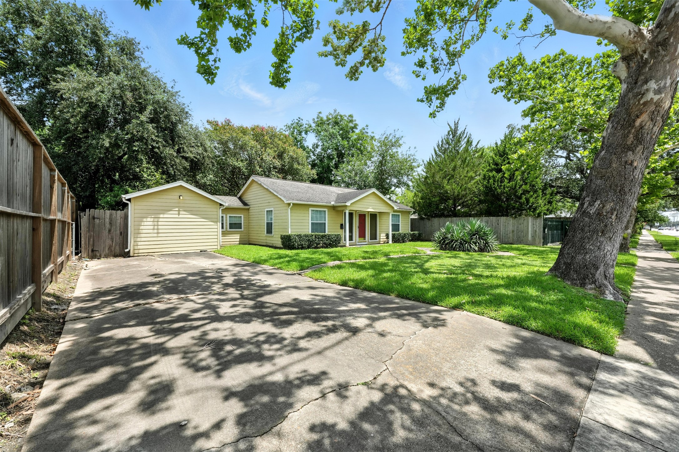 6305 South Rice Avenue Bellaire, TX 77401 - Photo 2 of 23 a front view of a house with a yard and garage