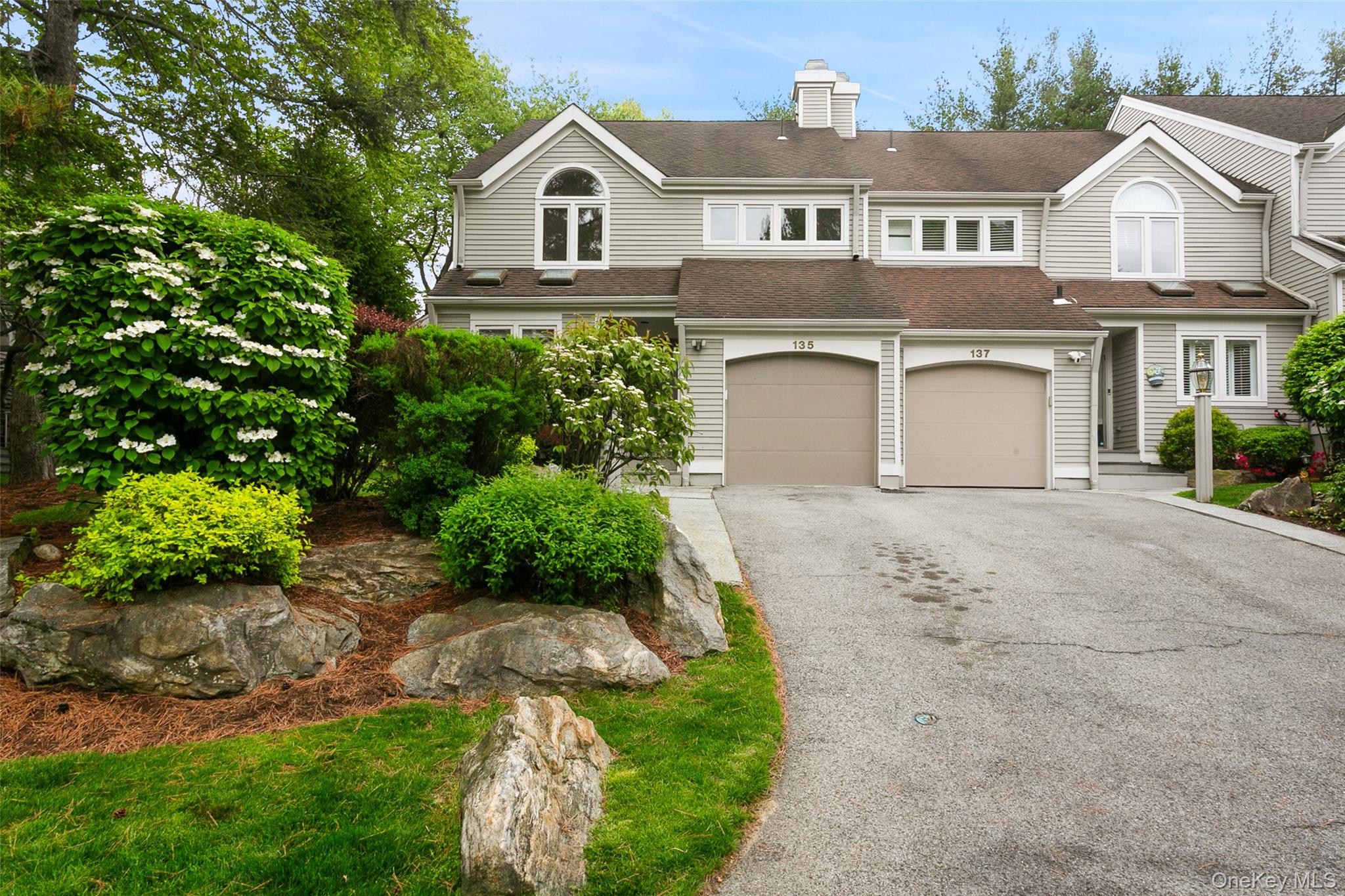 135 Boulder Ridge Road, Unit E87 Scarsdale, NY 10583 - Photo 3 of 47 a front view of a house with a yard and garage