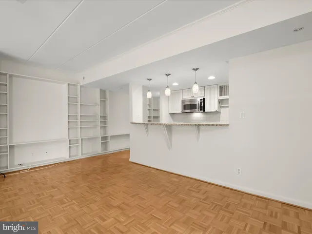 a view of a kitchen with refrigerator and white cabinets