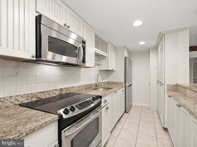 a kitchen with stainless steel appliances granite countertop a stove and a microwave