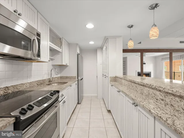 a large kitchen with stainless steel appliances granite countertop a stove and a sink