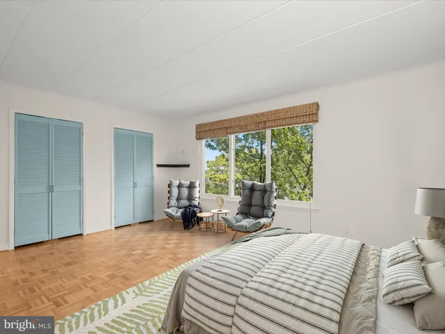 a bedroom with a bed and large windows