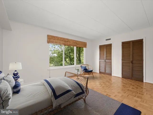 a bedroom with a bed and a large window