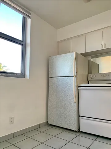a white refrigerator freezer and a stove sitting inside of a kitchen