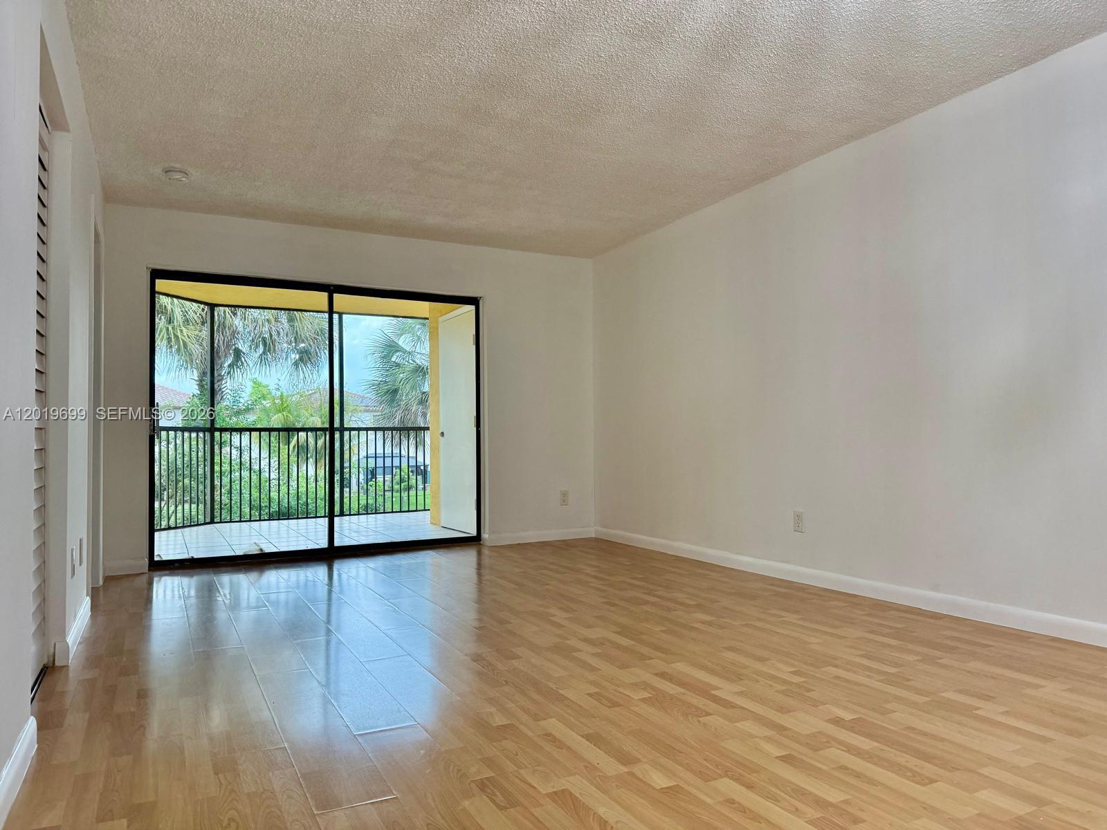 3470 Foxcroft Road, Unit 204 Miramar, FL 33025 - Photo 11 of 40 a view of an empty room with wooden floor and a window