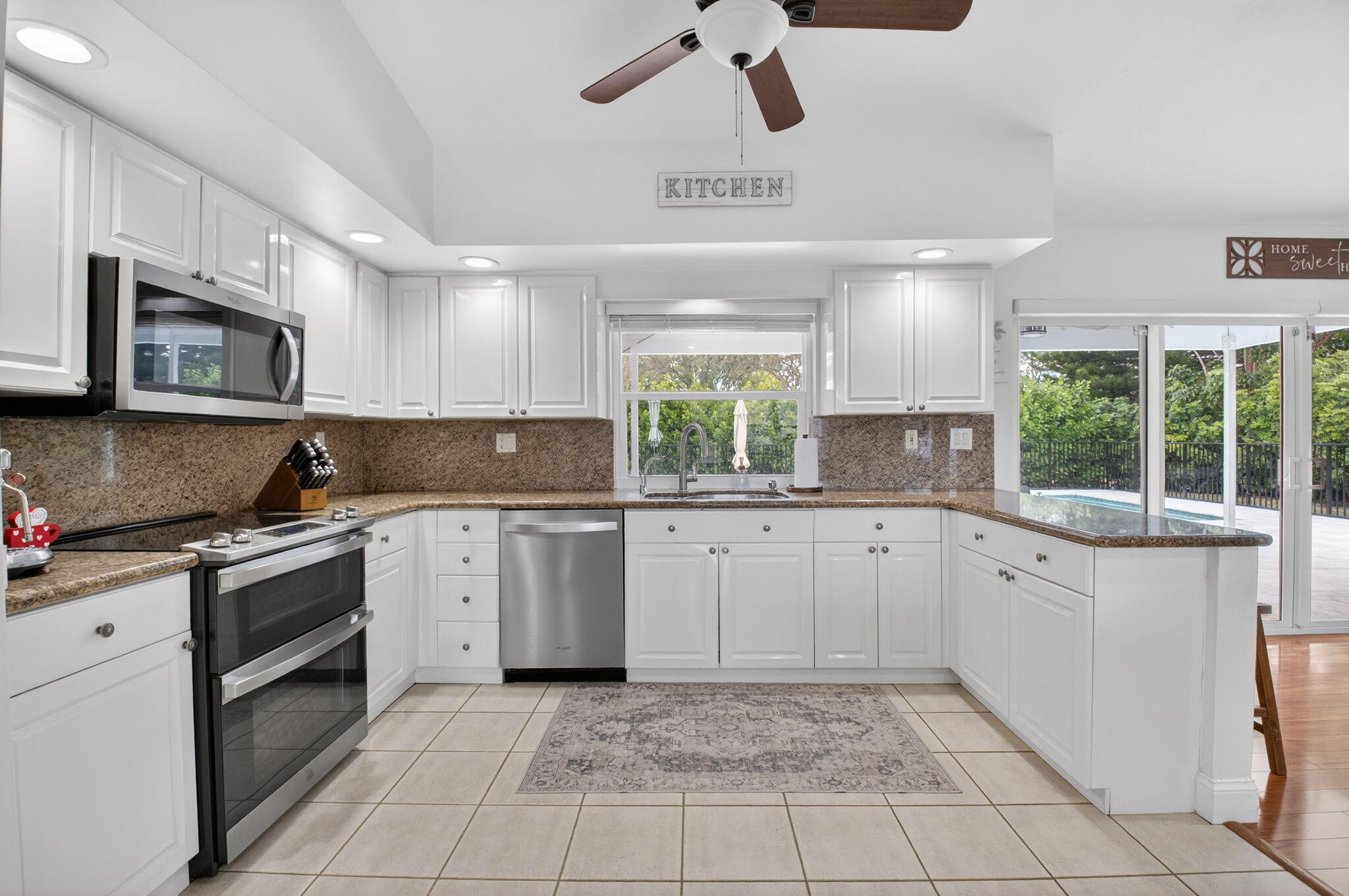 10302 Crosswind Road Boca Raton, FL 33498 - Photo 8 of 27 a kitchen with a sink window and cabinets