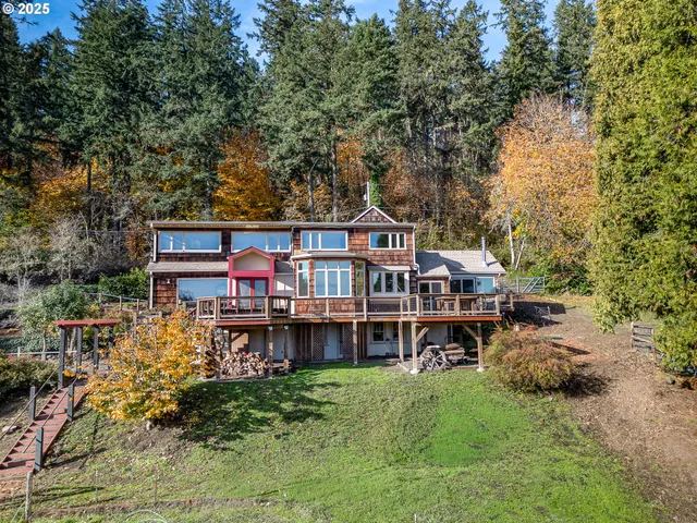an aerial view of a house with a big yard and large trees