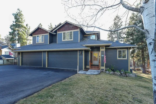 a front view of a house with yard and trees