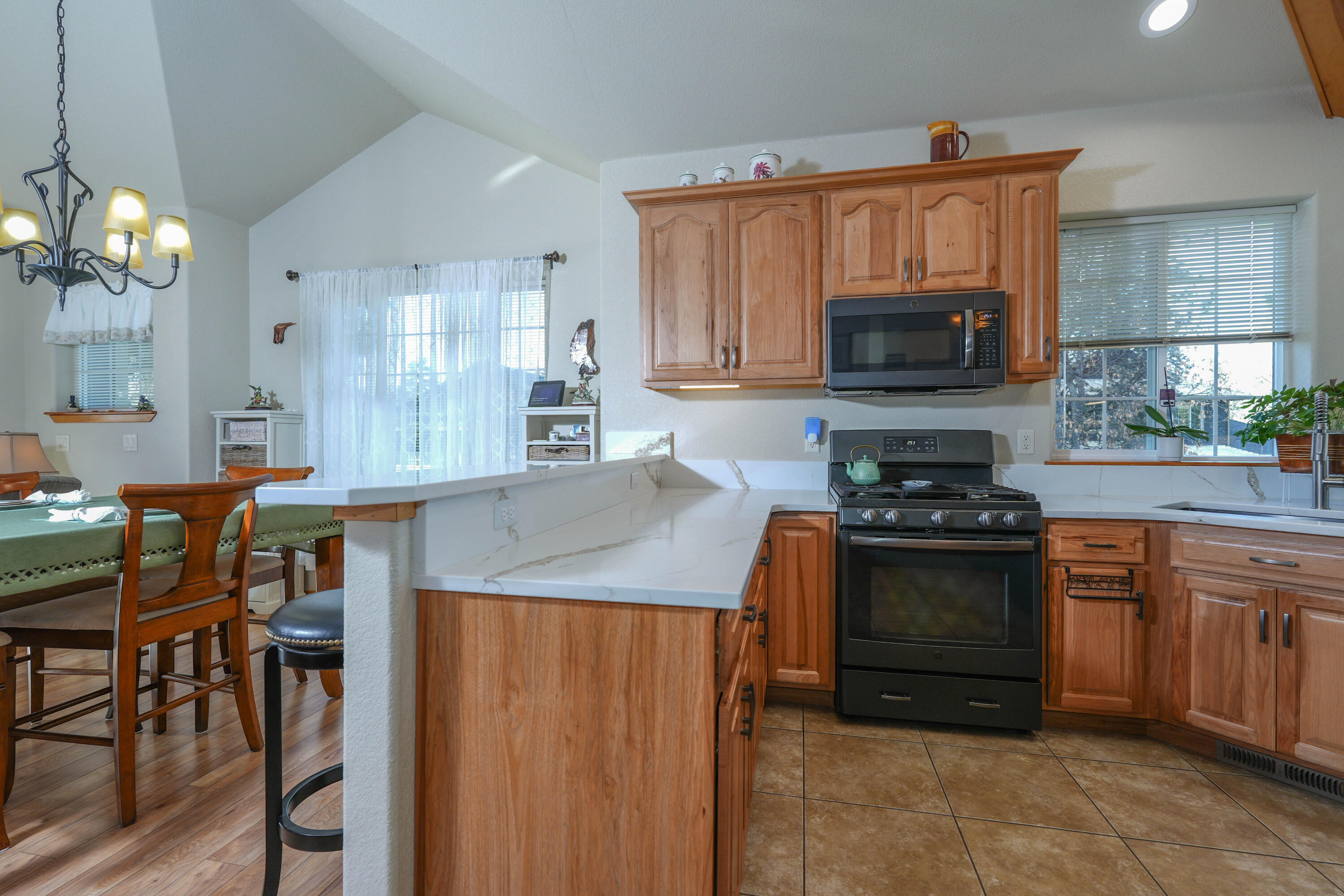 5028 Sora Loop Klamath Falls, OR 97601 - Photo 10 of 62 a kitchen with stainless steel appliances granite countertop a stove top oven a sink dishwasher and a refrigerator with wooden cabinets