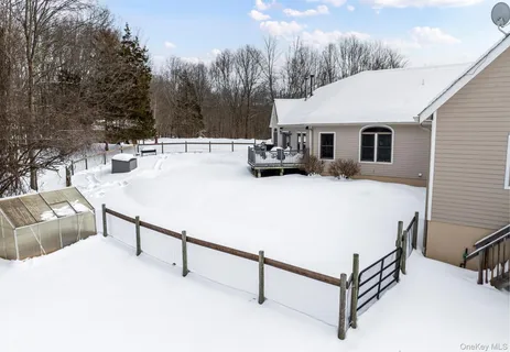 a view of a wooden house with a yard and wooden fence
