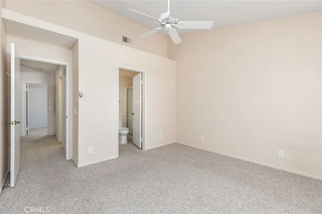an empty room with a ceiling fan and a window