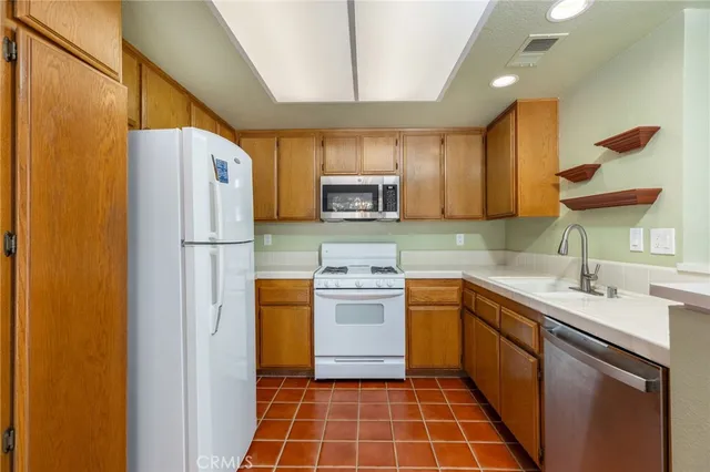 a kitchen with a sink a refrigerator a stove a washer dryer and cabinets