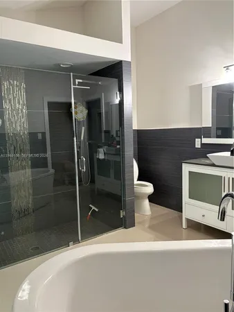 a bathroom with a sink a toilet and shower