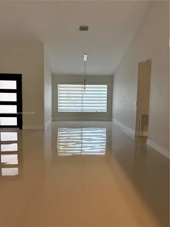 a view of empty room with stairs and windows