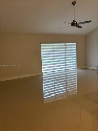 a view of a room with a window and ceiling fan