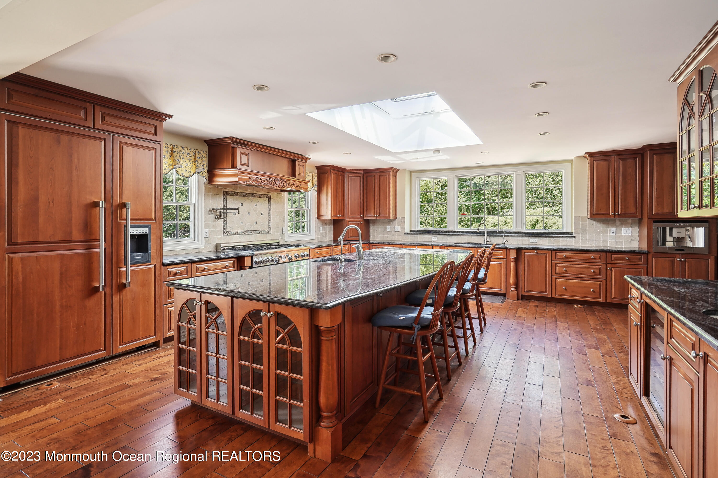 51 Cherry Tree Farm Road Middletown, NJ 07748 - Photo 33 of 62 a kitchen with stainless steel appliances granite countertop a stove a refrigerator a sink a dining table and chairs with wooden floor