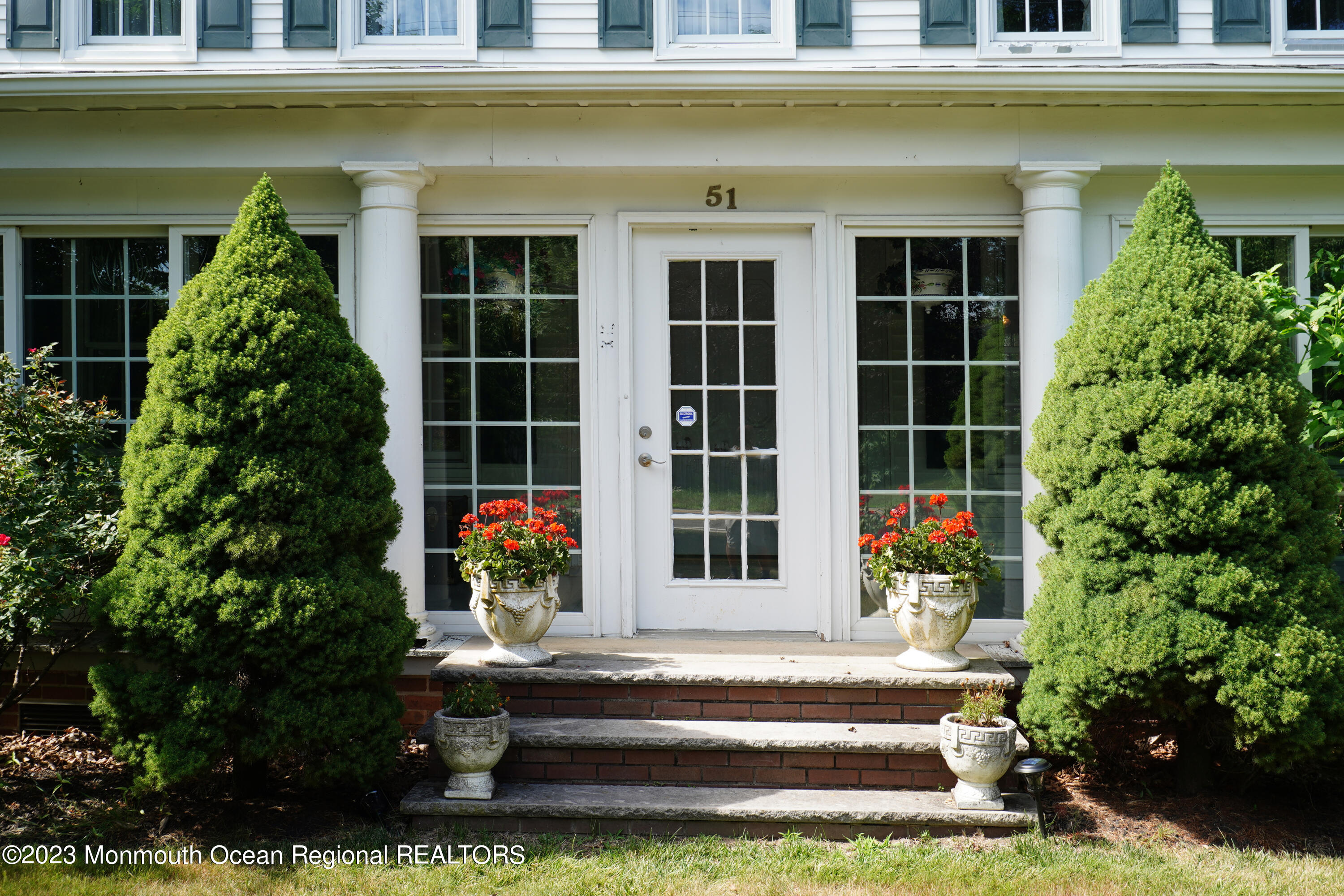 51 Cherry Tree Farm Road Middletown, NJ 07748 - Photo 5 of 62 a front view of a building with a garden and plants