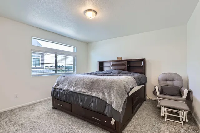 a bedroom with a bed chair and window