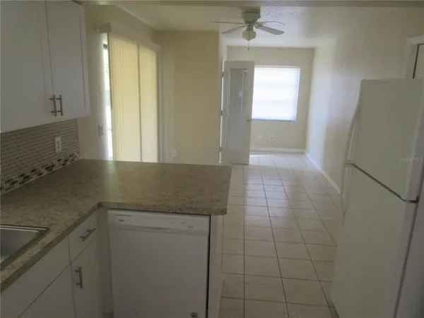 a kitchen with granite countertop a sink and a refrigerator