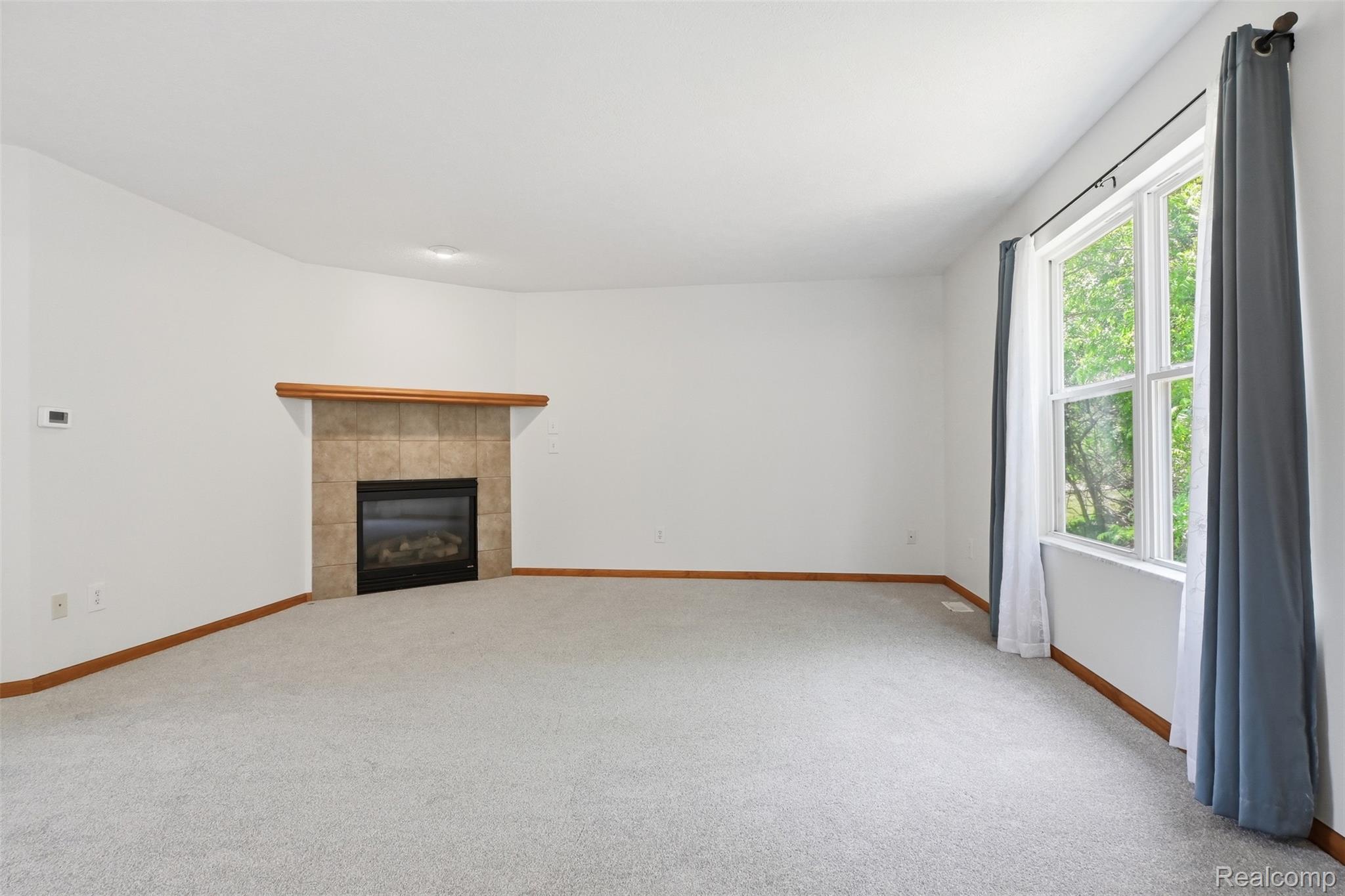 4482 Pleasant Valley Road Brighton, MI 48114 - Photo 6 of 35 Bright interior space featuring a fireplace with a tiled surround and wood mantel