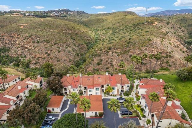 an aerial view of residential houses with outdoor space and ocean view