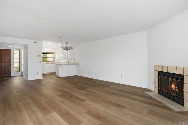 a view of empty room with wooden floor and fireplace