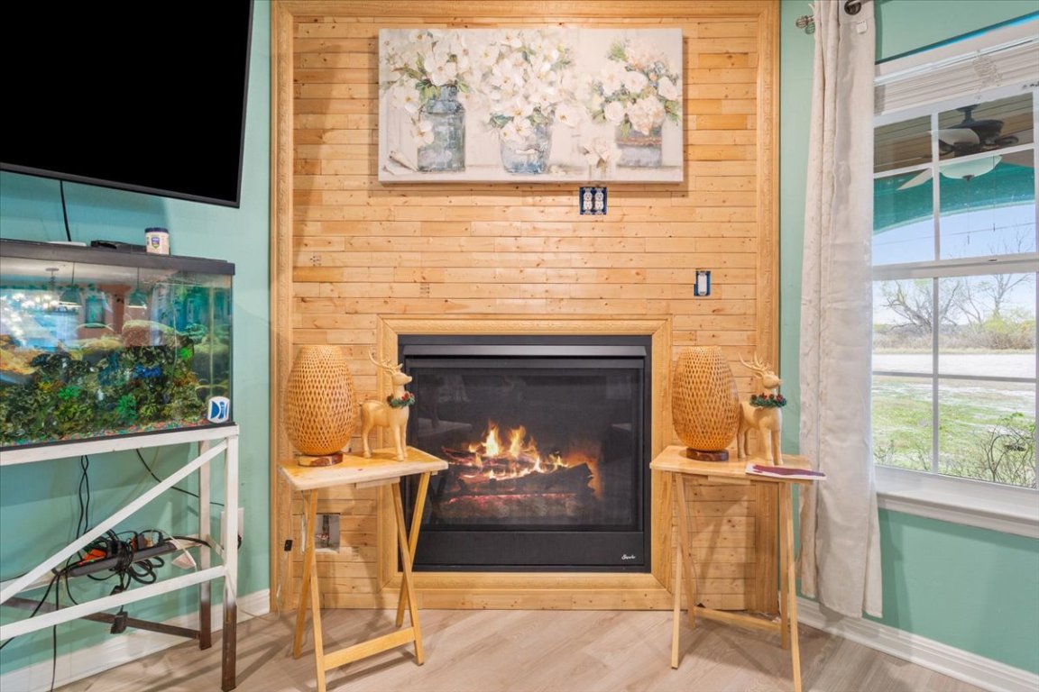 50 Dusty Dam Road Coupland, TX 78615 - Photo 9 of 38 A beautiful fireplace anchors the living area, offering both warmth and ambiance while enhancing the home’s cozy appeal.