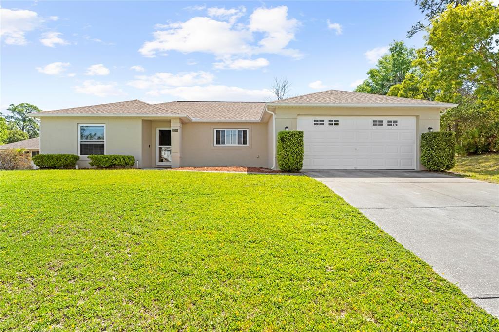 13040 Hanley Drive Spring Hill, FL 34609 - Photo 1 of 1 a front view of house with yard and trees