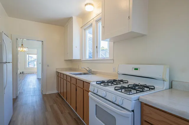 a kitchen that has a stove and a wooden floor