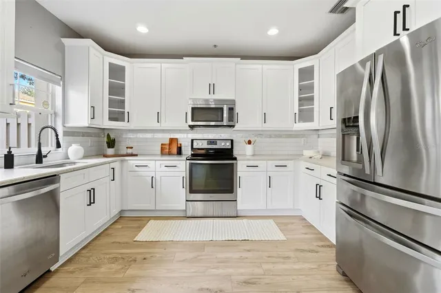 a kitchen with sink a microwave and cabinets