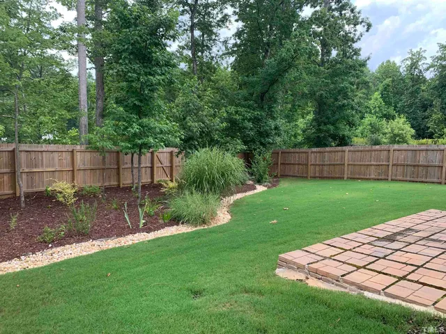 a front view of a house with a yard and fence