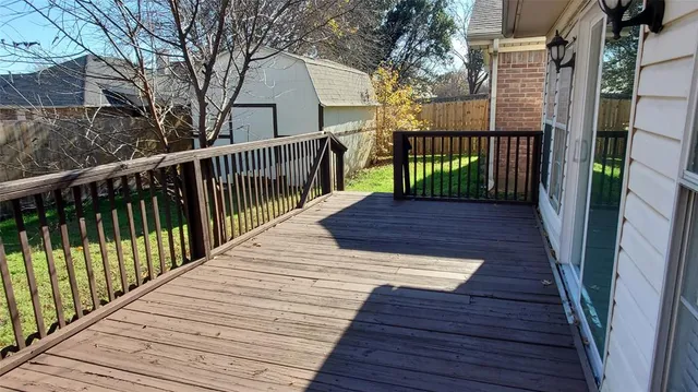 a view of a balcony with wooden floor and fence