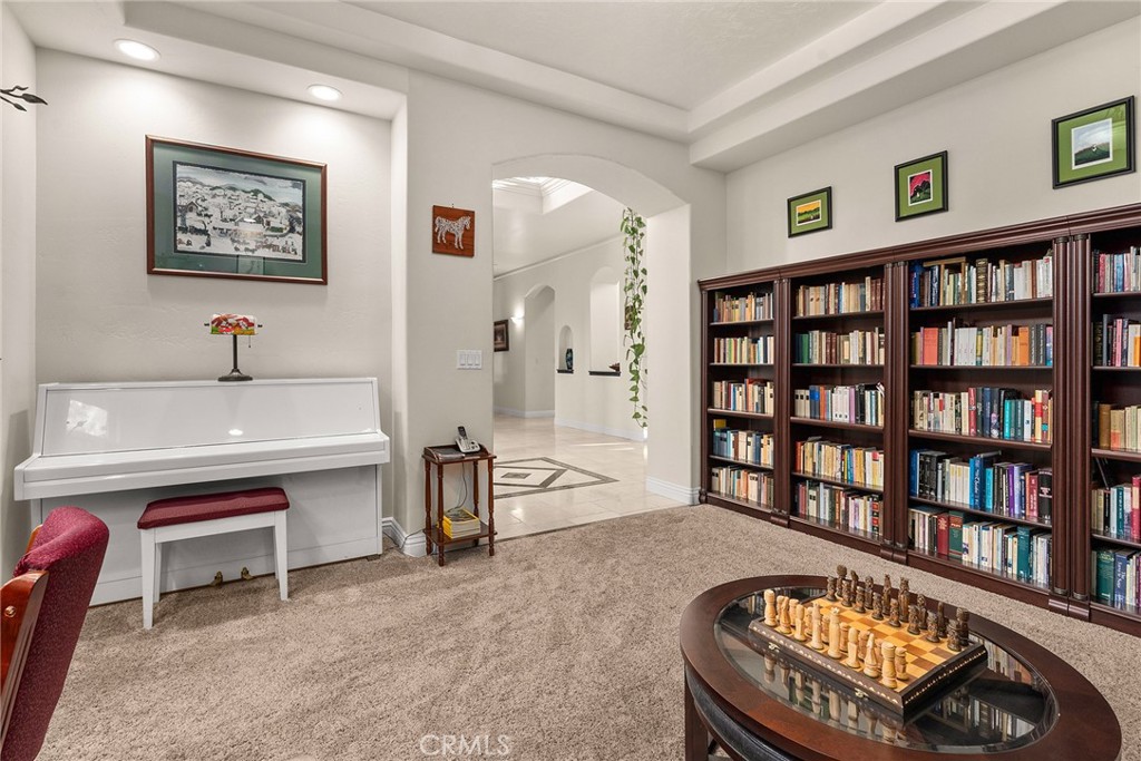 3171 Sandstone Lane Chico, CA 95928 - Photo 17 of 70 a living room with furniture a piano and a bookshelf