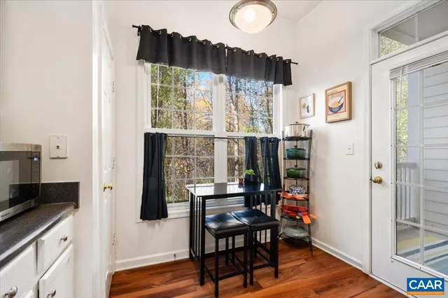 a kitchen with stainless steel appliances a table chairs and a refrigerator