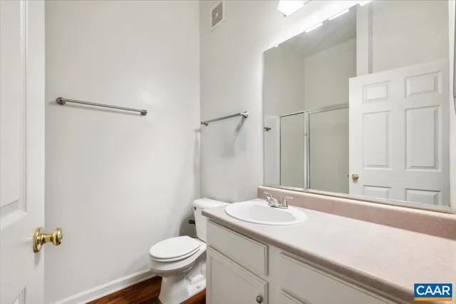 a bathroom with a granite countertop sink toilet and a mirror