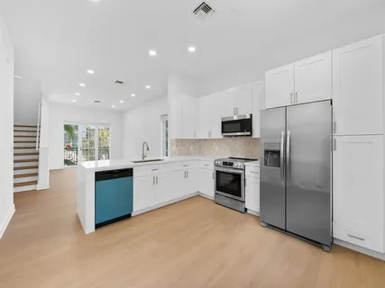 a large kitchen with a refrigerator and a stove top oven