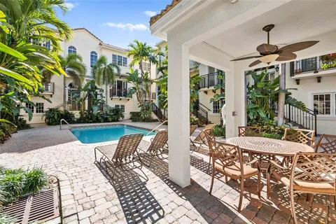 a view of a patio with couches table and chairs and potted plants