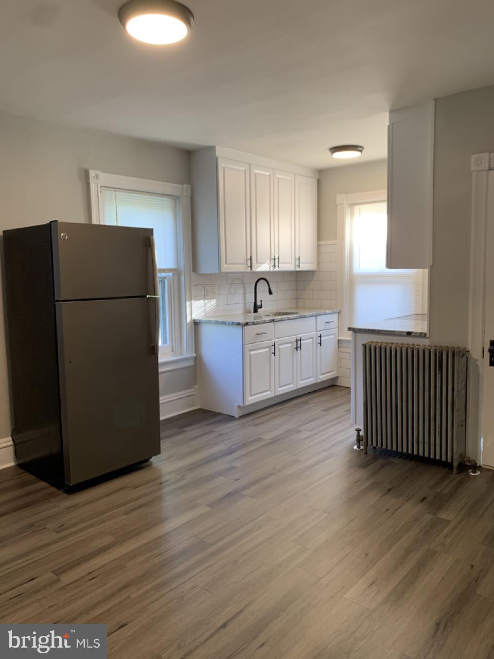 a kitchen with stainless steel appliances granite countertop a refrigerator a stove a microwave and a large window