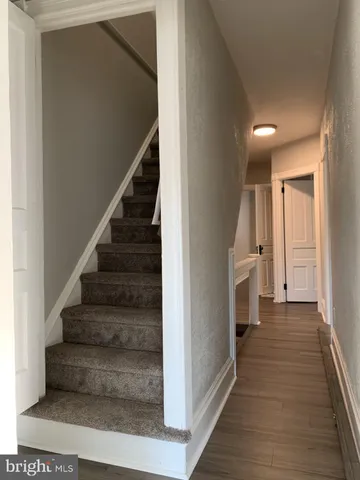 a view of a hallway with wooden floor and entryway