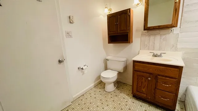 a bathroom with a sink toilet and mirror