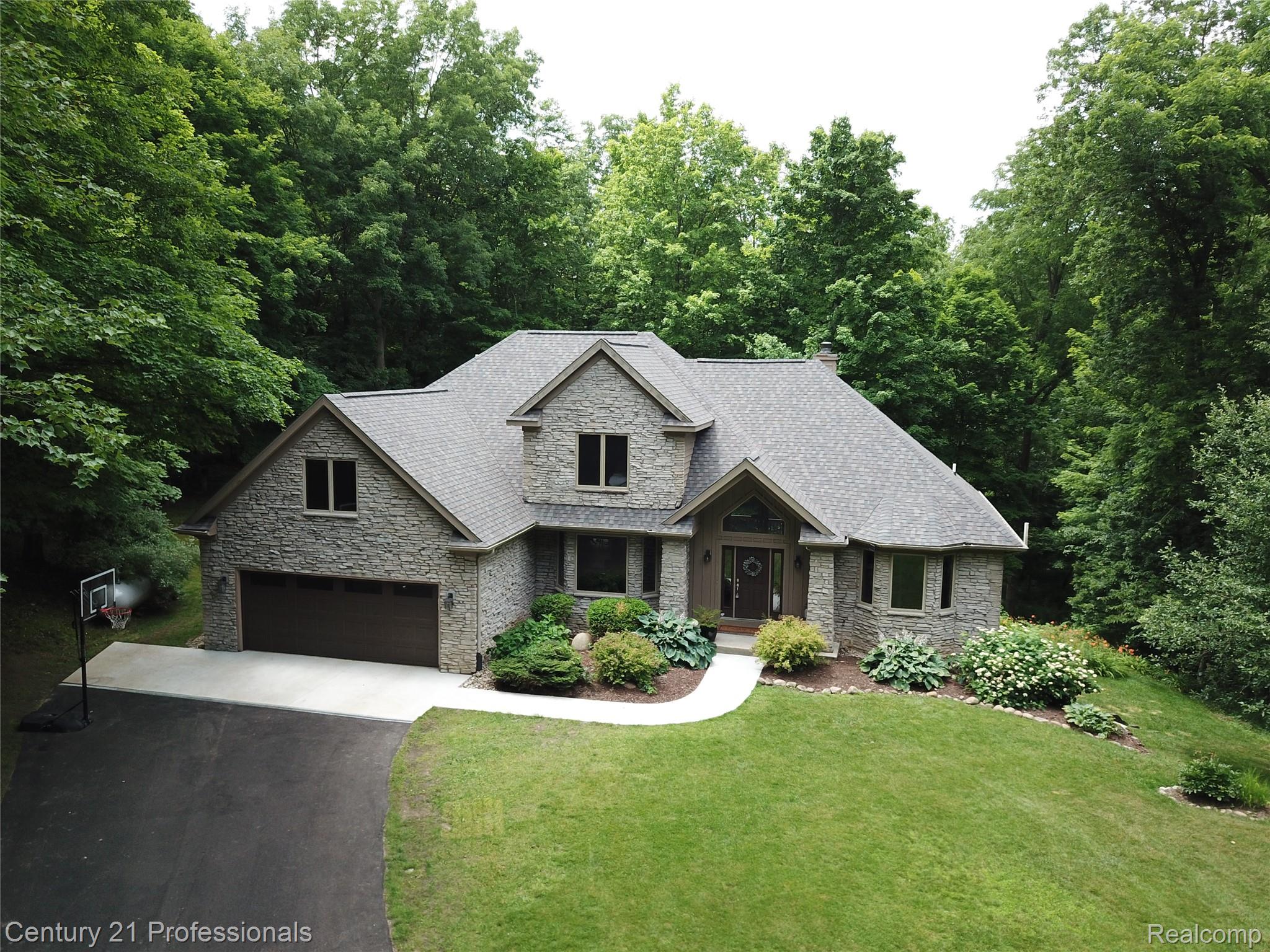 9867 Rainbow Ridge Drive Schoolcraft, MI 49087 - Photo 3 of 82 Stone veneer exterior with a multi-gabled roof and an arched entryway
