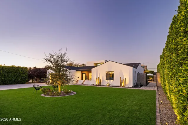 a very nice looking house with a big yard and potted plants